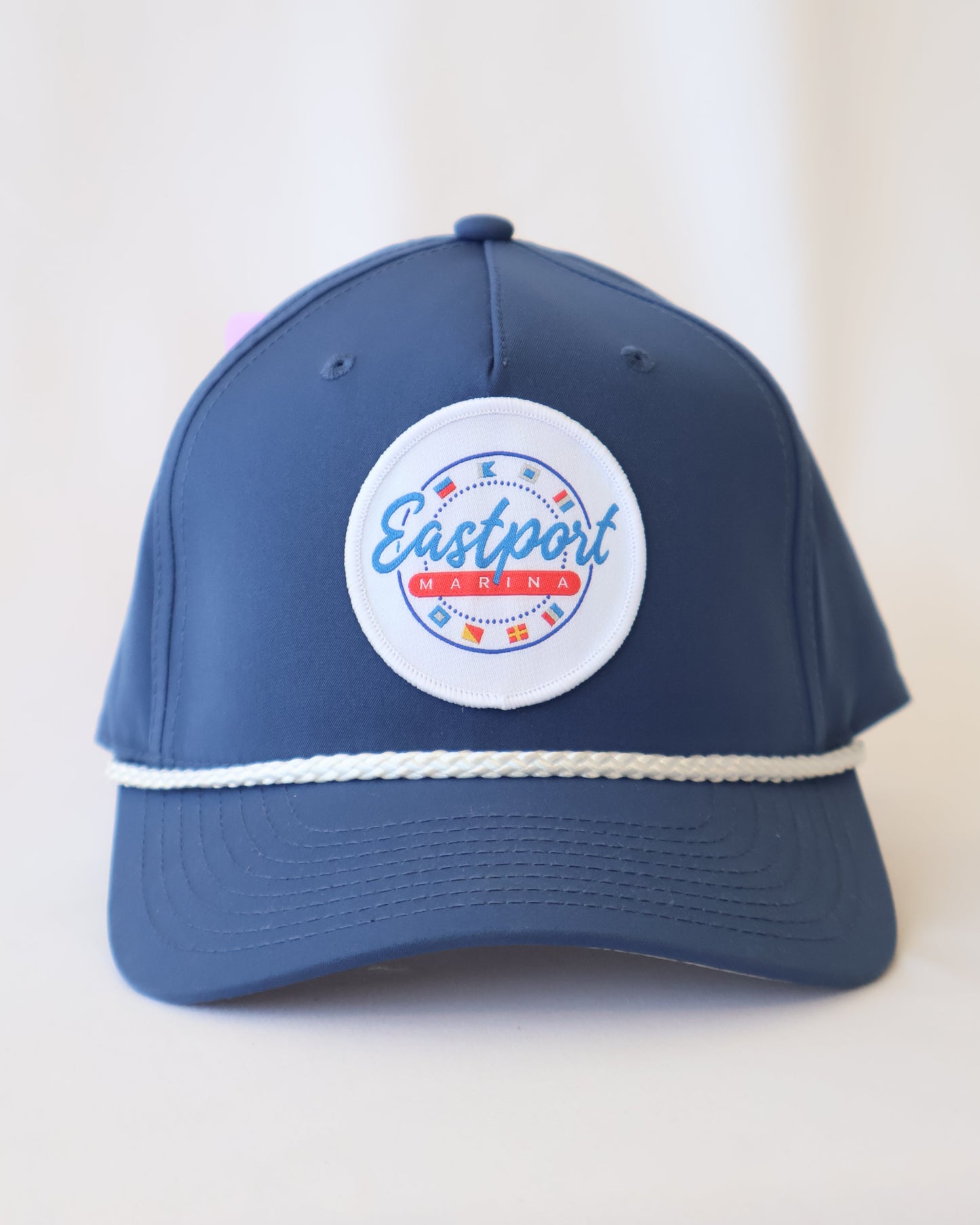 Blue cap with a white logo on a light beige background