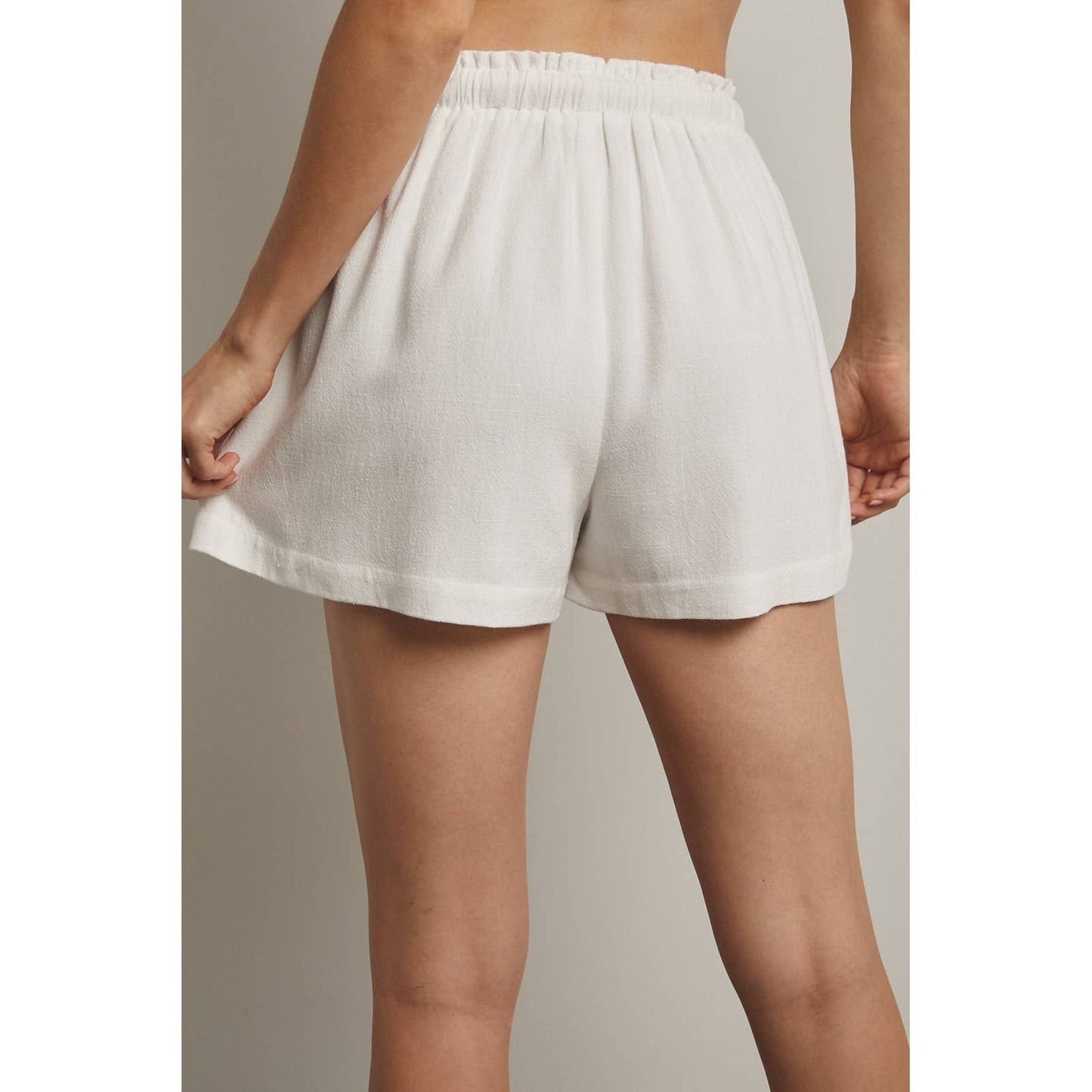 White shorts worn by a person on a neutral background