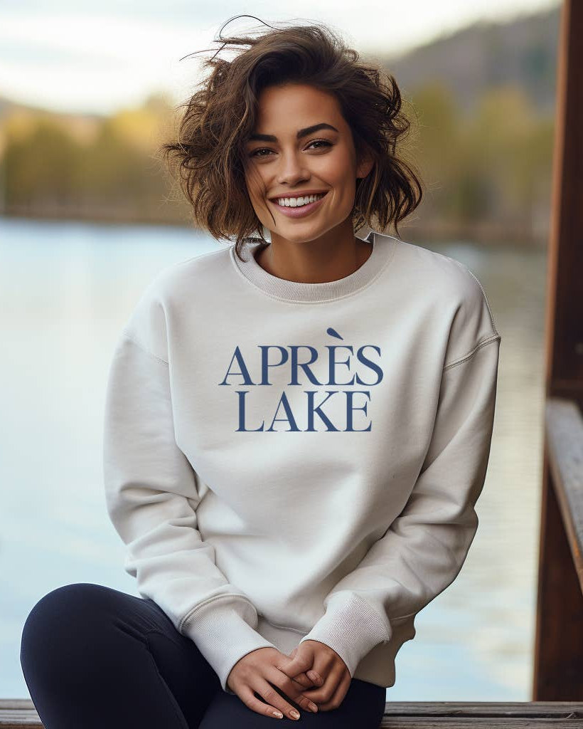 Woman wearing a 'APRèS LAKE' sweatshirt by a lake.