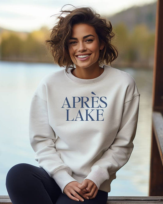 Woman wearing a 'APRèS LAKE' sweatshirt by a lake.