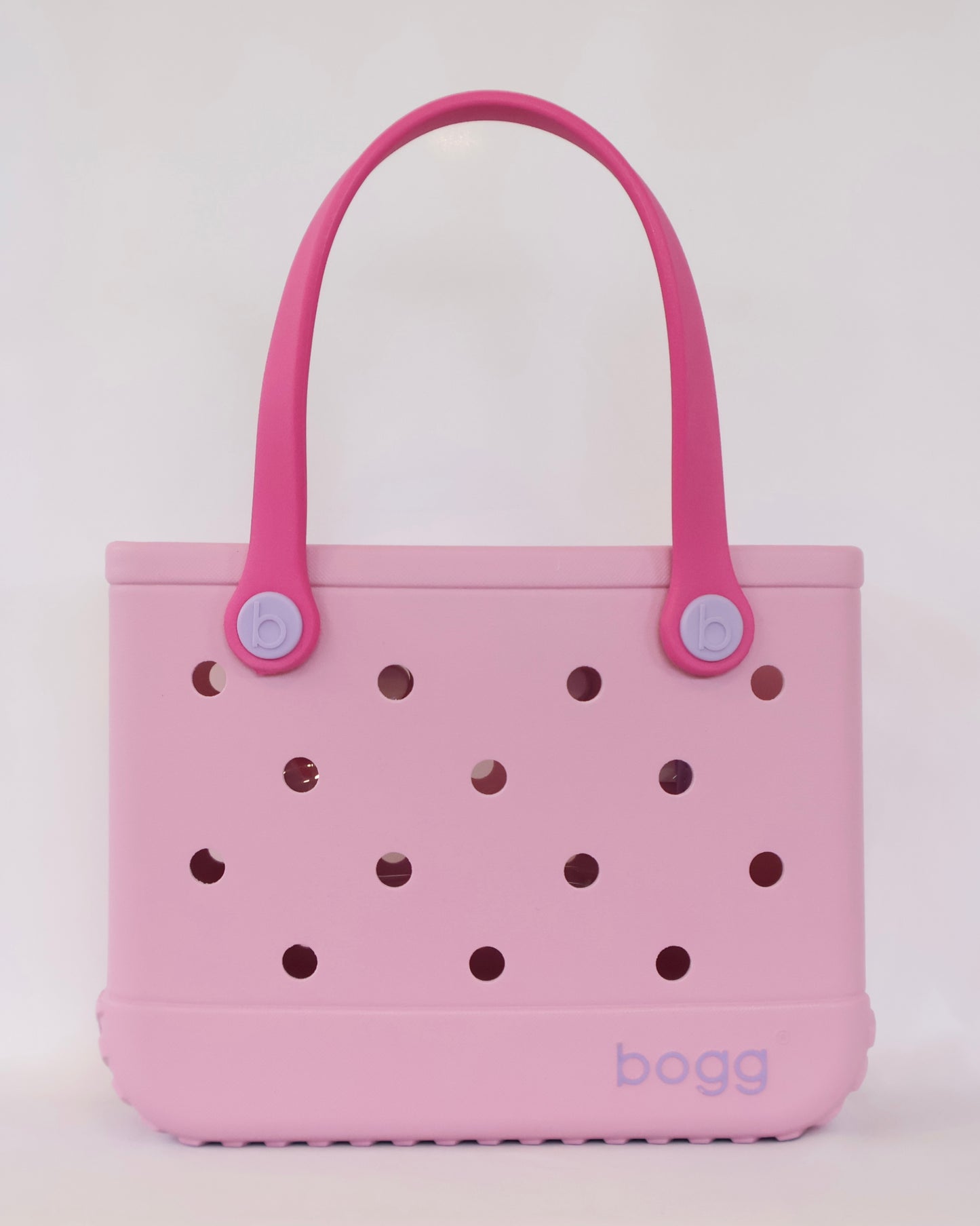 Pink tote bag with brown polka dots and pink handles on a white background