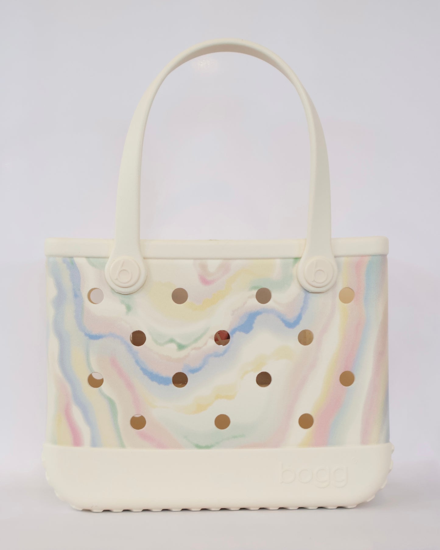 Handbag with rainbow pattern and gold polka dots on a light gray background