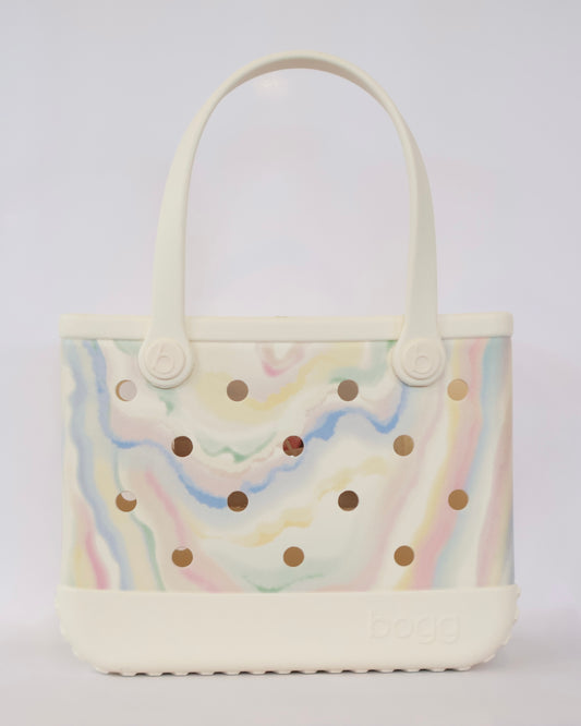 Handbag with rainbow pattern and gold polka dots on a light gray background