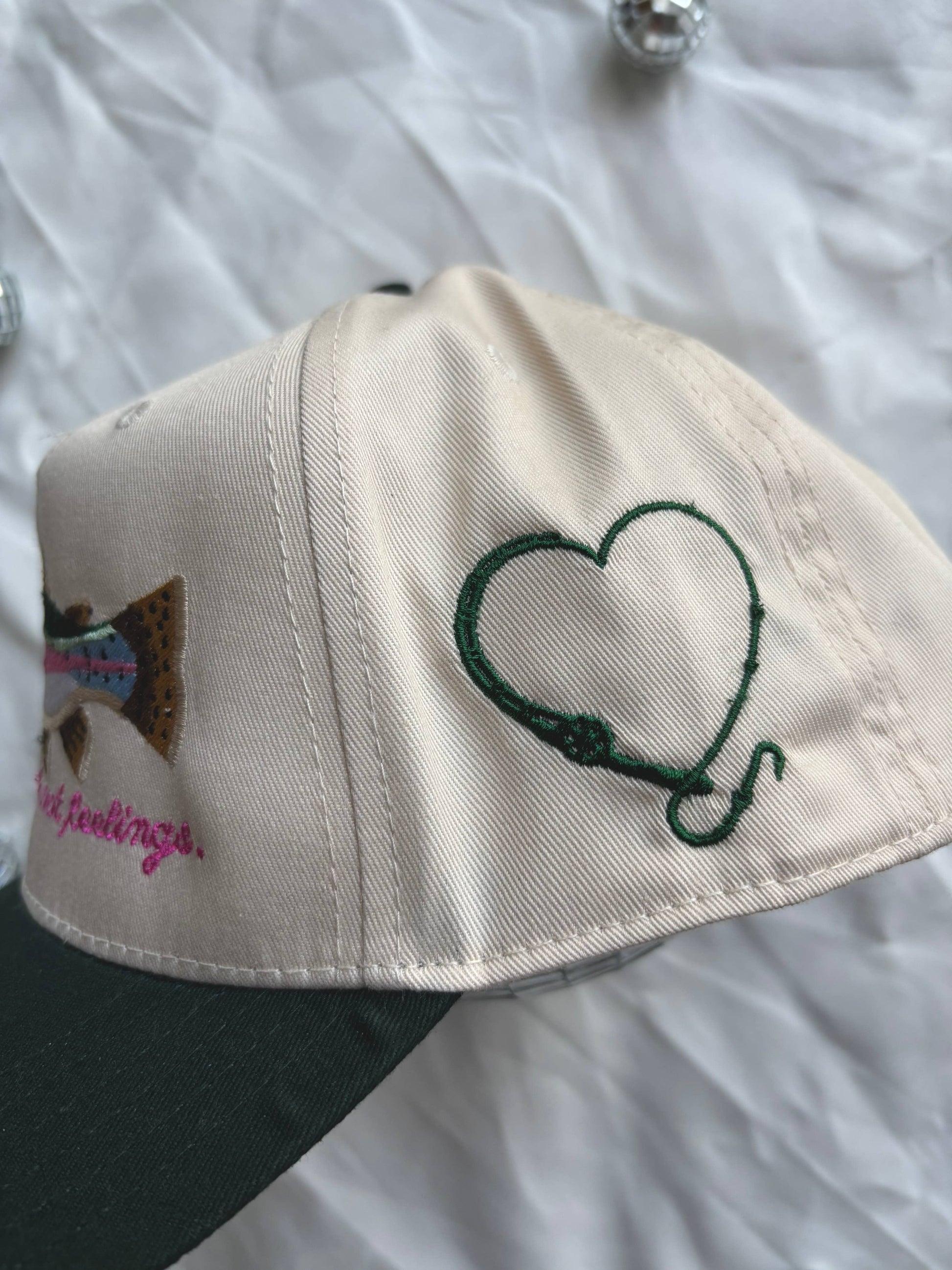 Cap with heart design and text on a white background