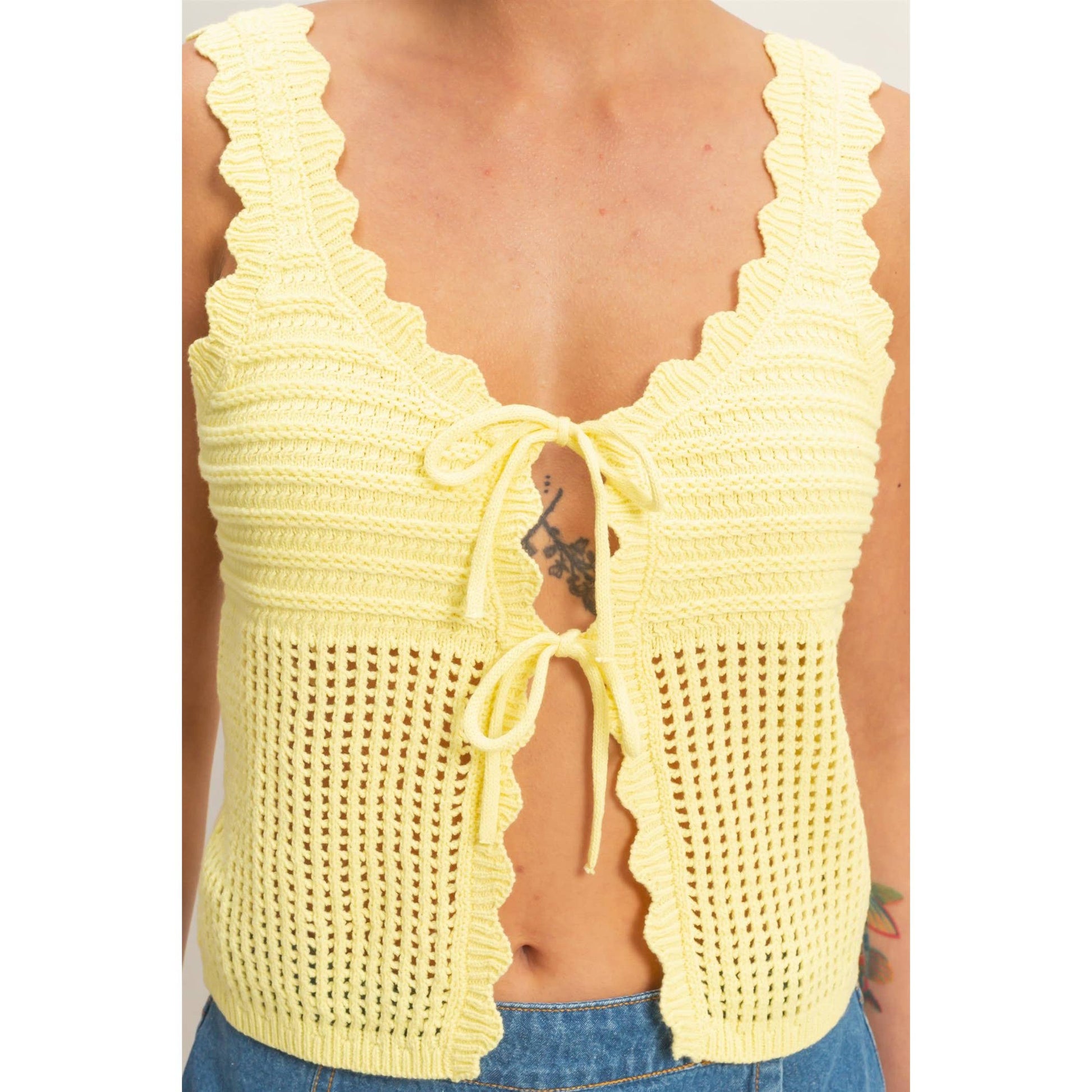 Yellow crochet top worn by a person on a white background