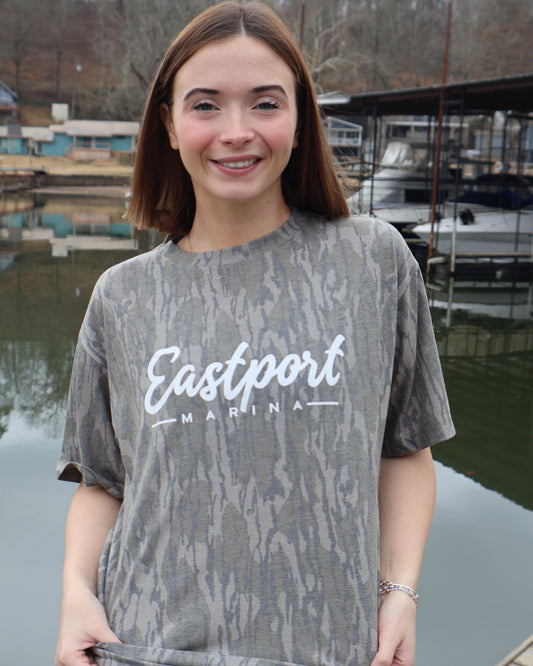 Person wearing a gray sweatshirt with 'Eastport' text, standing by water.