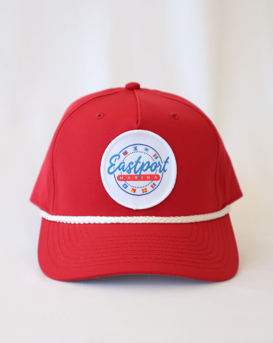 Red cap with a white logo on a light beige background