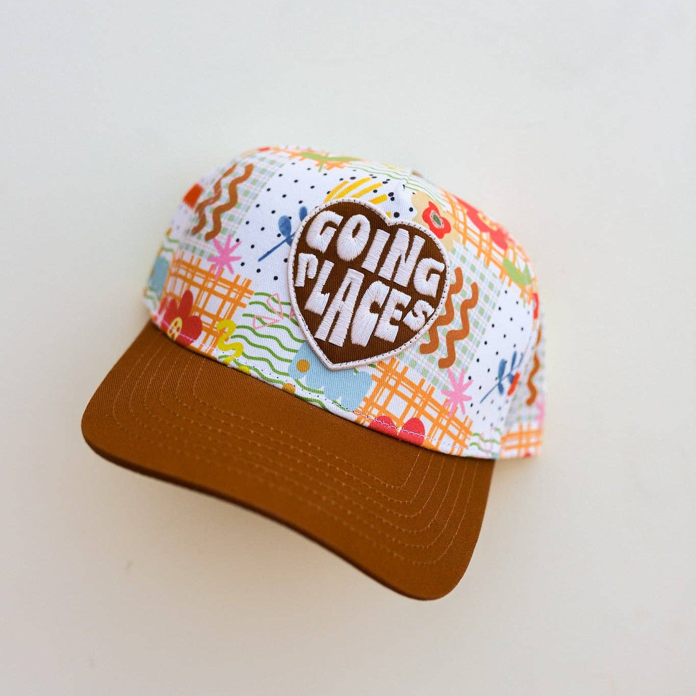 Colorful cap with 'Going Places' text on a light gray background