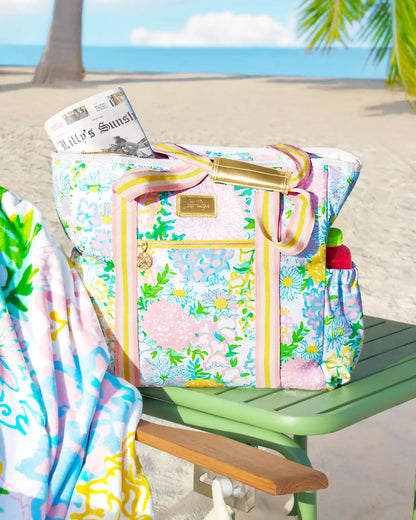 Colorful beach bag with floral pattern on a green chair by the beach