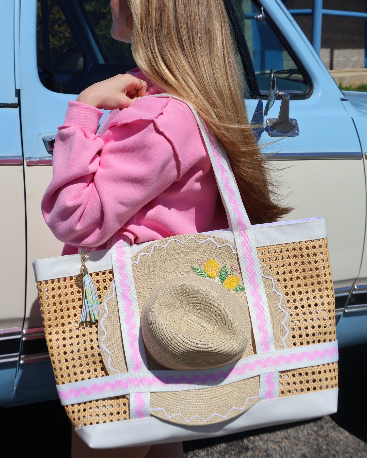 Pink hoodie and straw hat on a chair with a blue background