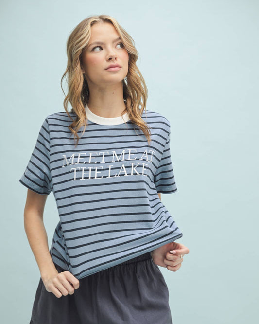 Woman wearing a striped shirt with 'Meet Me at the Lake' text on a light blue background