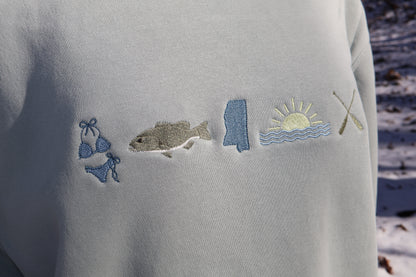 Lake Embroidered graphic on a light green sweatshirt with a snow background