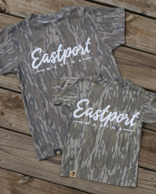 Gray camouflage baby romper with 'Eastport' branding on a wooden surface