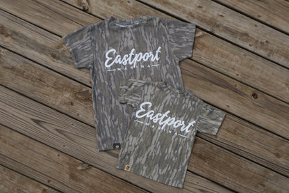 Two camouflage-patterned shirts with 'Eastport' branding on a wooden surface