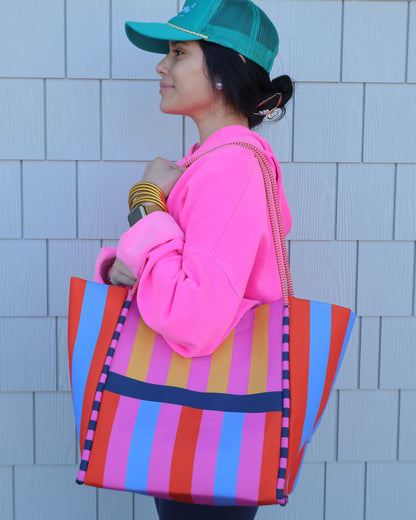 Person lying on a tiled floor with colorful bags and accessories