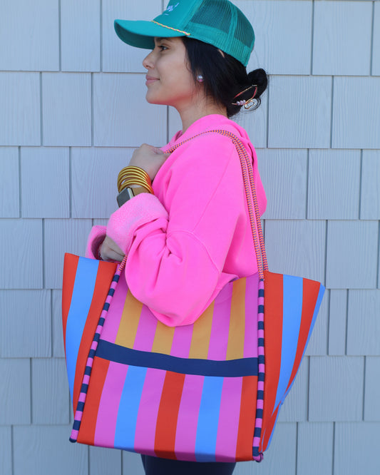 Person lying on a tiled floor with colorful bags and accessories
