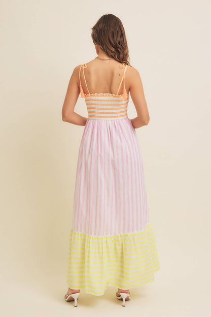 Woman wearing a colorful striped dress with a plain background