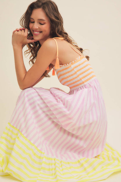 Woman wearing a colorful striped dress with a plain background