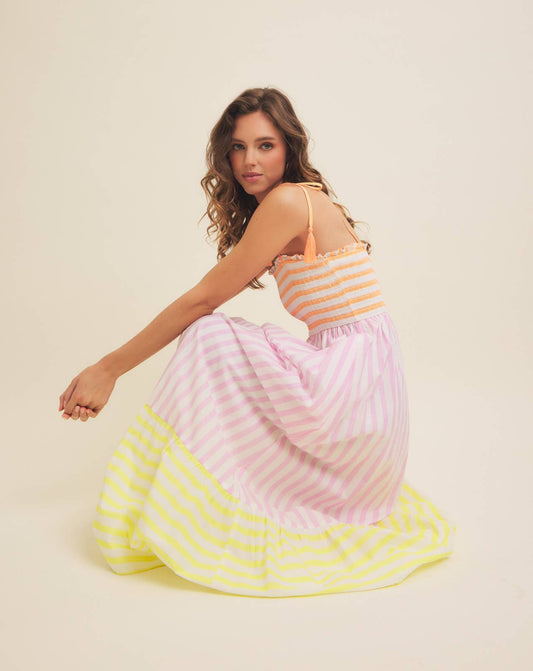 Woman wearing a colorful striped dress on a beige background